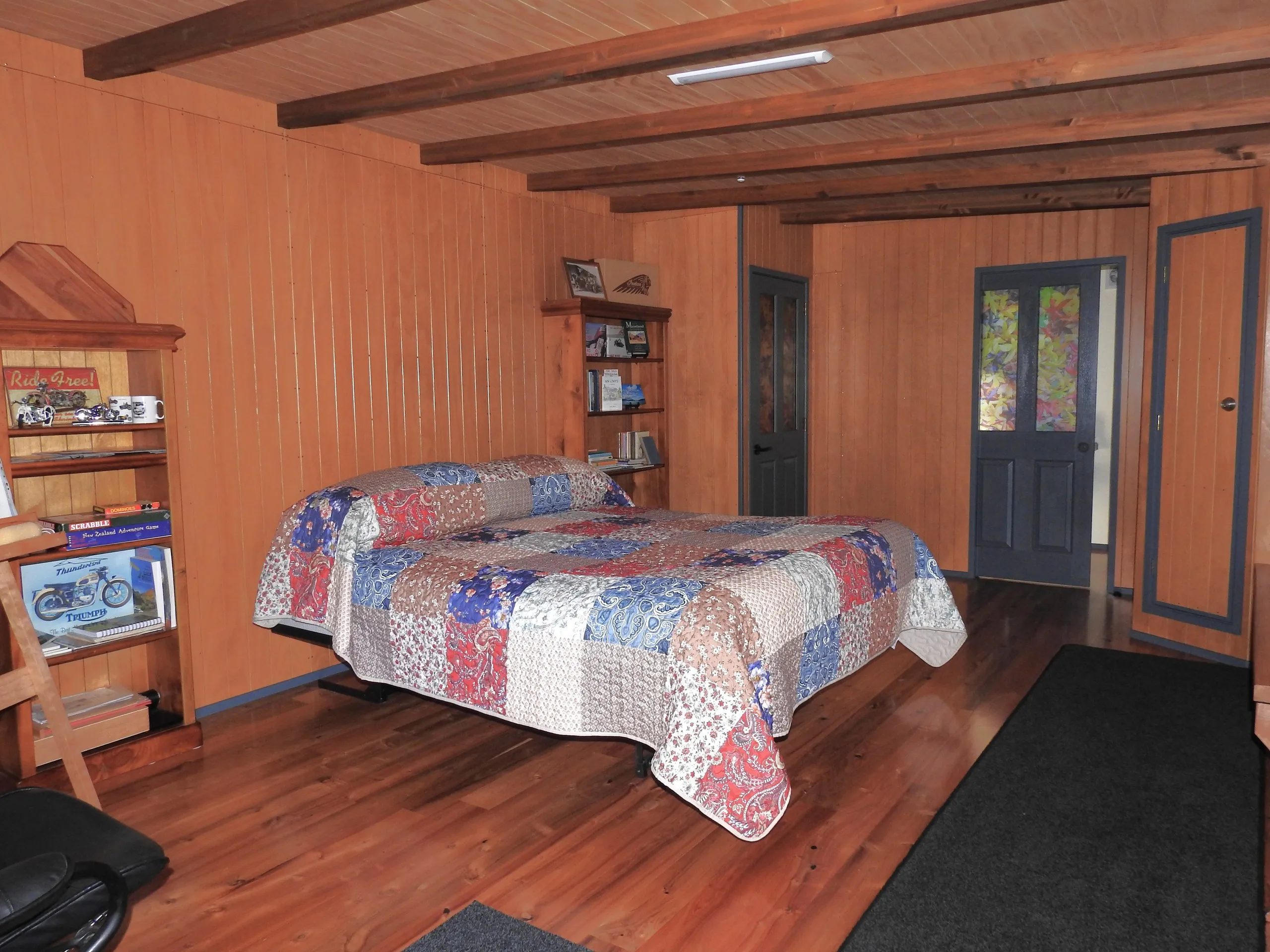 A warm bedroom with patchwork quilt and a door open to the outside