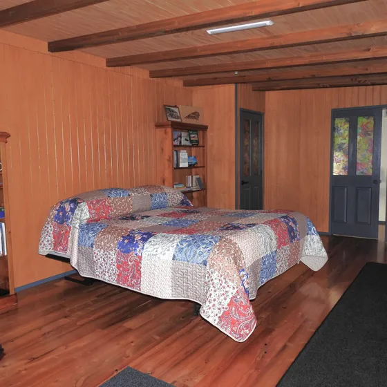 A warm bedroom with patchwork quilt and a door open to the outside
