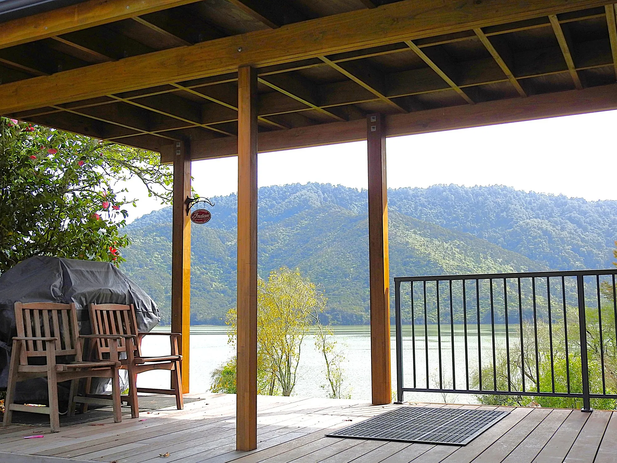 The sheltered rear deck beside the cabin entrance, set up as the barbecue area