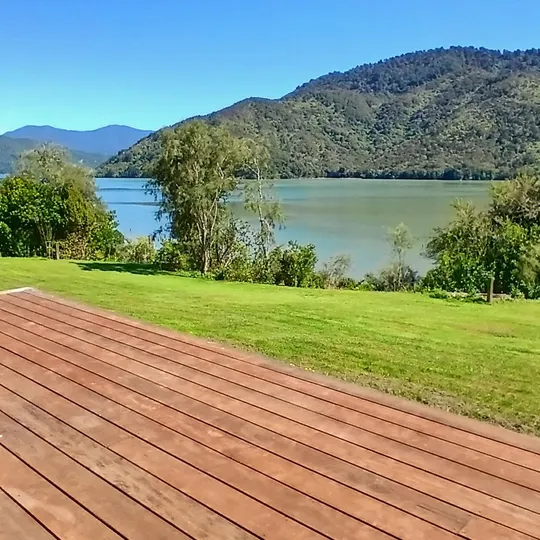A cafe table on the deck overlooking the calm green water of the Sounds