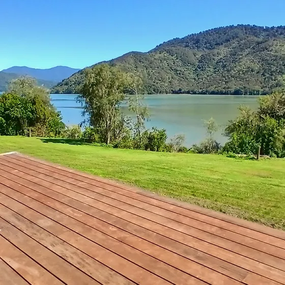 A cafe table on the deck overlooking the calm green water of the Sounds