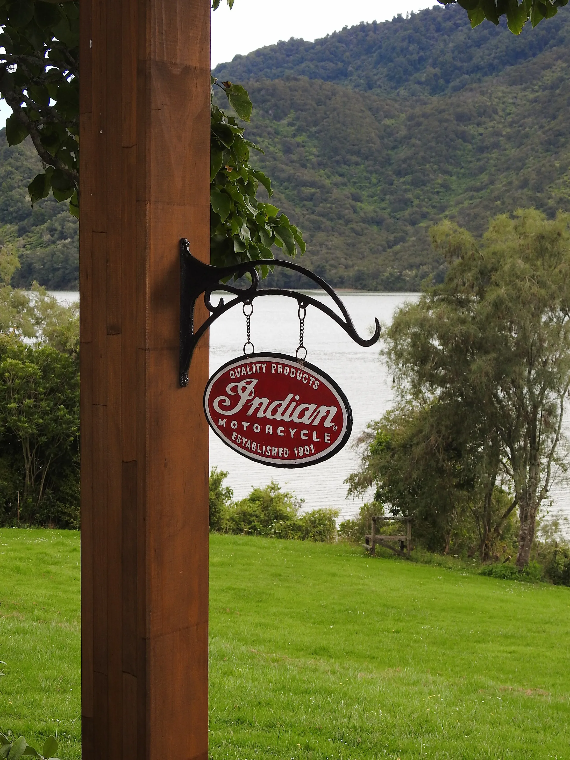 A vintage Indian Motorcycle enamel sign hanging from a timber post, the Sound behind