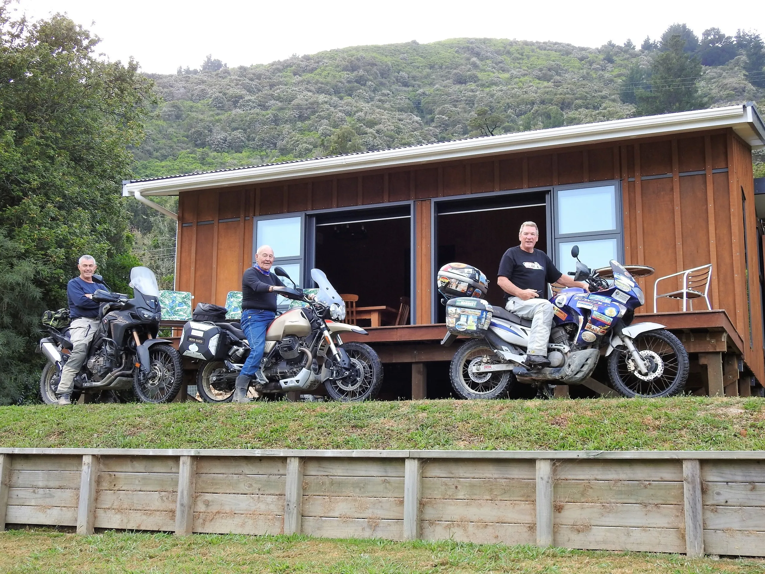 Adventure motorbikes and their riders in front of the cabin — riders are welcome
