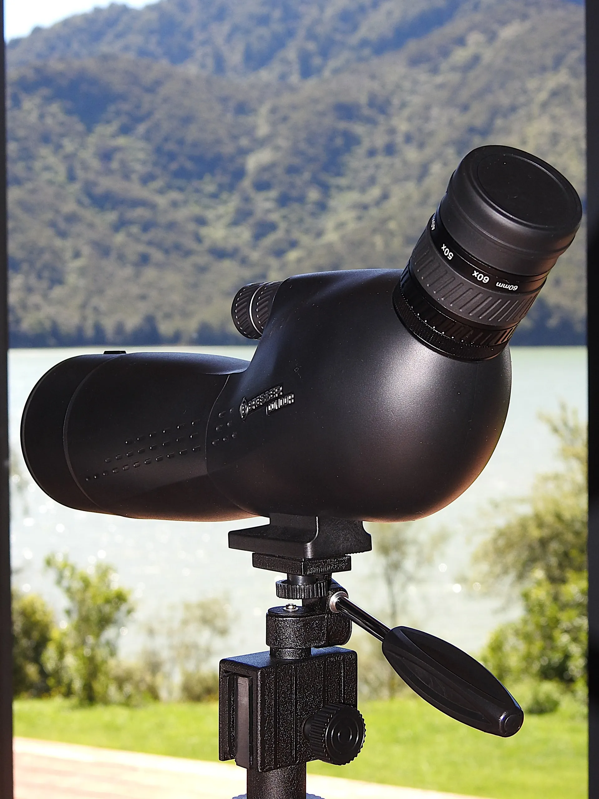 A spotting scope on the deck for watching birds and the water